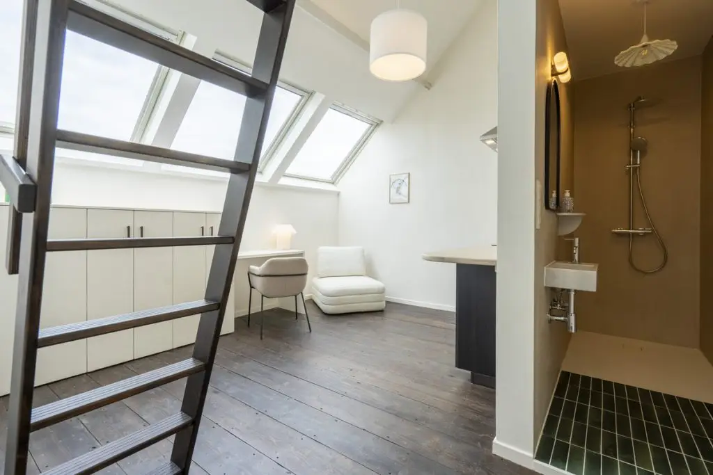 Stylish studio room in coliving space: cozy bed, sleek kitchen, contemporary bathroom